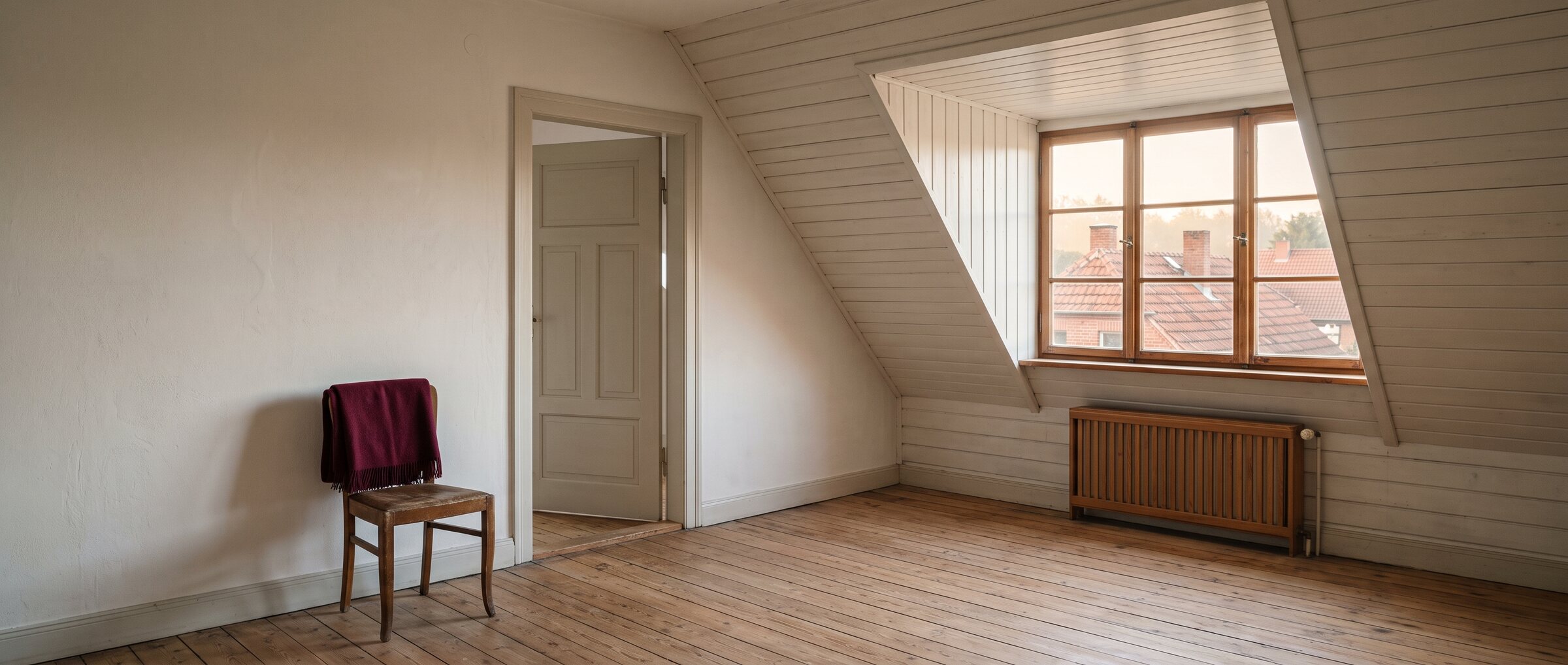 KI-generiertes Symbolbild: leeres Zimmer unter einer Dachschr&auml;ge mit Gaube, Dielenboden und Blick auf rote Ziegeld&auml;cher