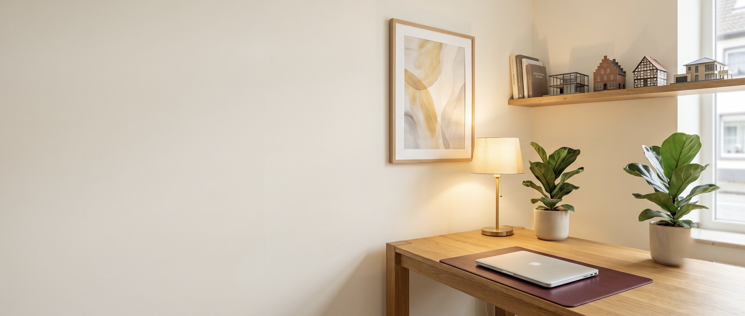 B&uuml;ro von Wohngef&uuml;hl Immobilien in Duisburg mit Schreibtisch, Hausmodellen und warmem Tageslicht